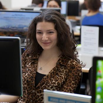 Business student with computer in classroom