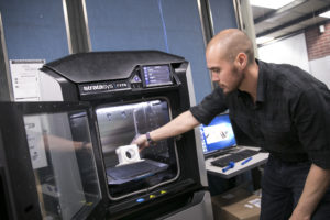 Student operating a 3D printer