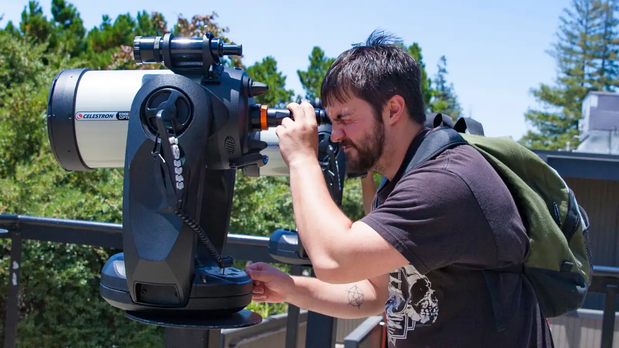 Student looking through telescope.