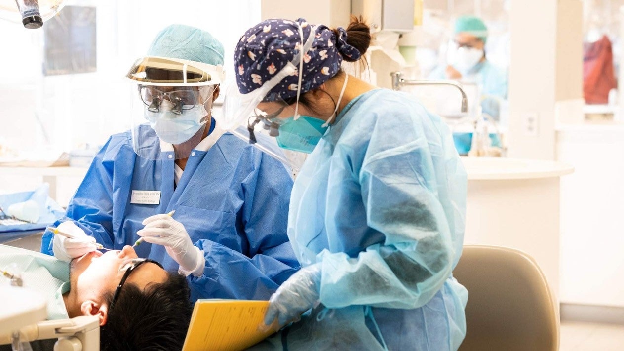 Dental hygiene students provide patient care in a clinical training lab.