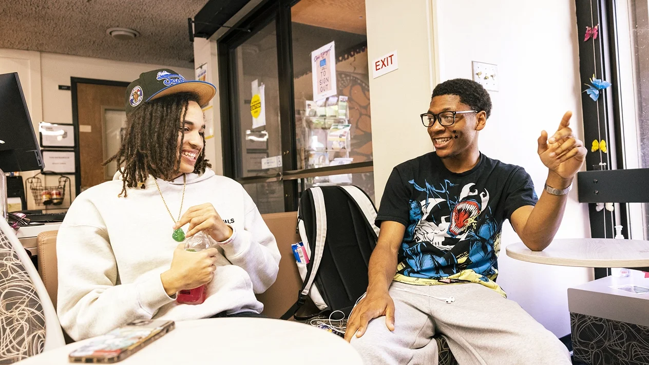 Two students talking at table
