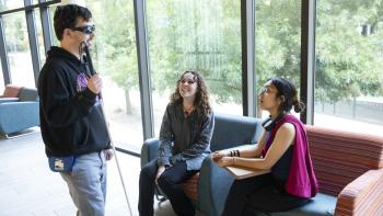 Visually-impaired student talking with other students on the DVC campus