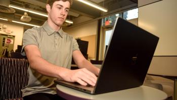 DVC community education and IBM cybersecurity student Justice Gaines working on his laptop