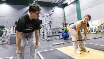 Two people exercise in a gym