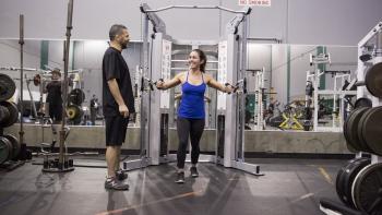Two people exercise in a gym