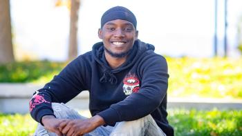 Smiling student seated outdoors on campus.