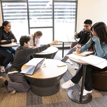 Group of students sitting around in a room chatting and discussing