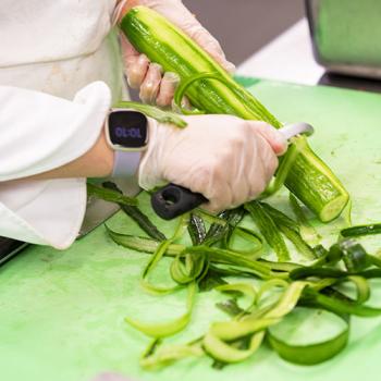 Person cutting a vegetable.