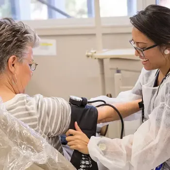 DVC Public Health - a health worker assisting senior citizen