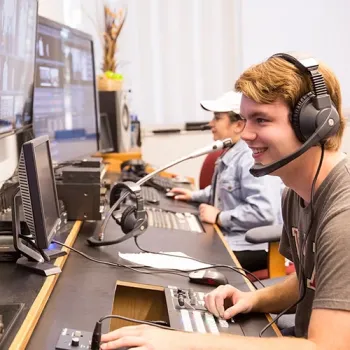 Film & TV students looking at monitors in a media studio environment