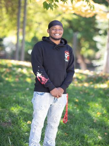 Smiling DVC student Shikeem Washington standing outdoors on campus.