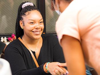 A woman happy and shaking hands with another woman