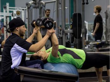 A personal trainer helps a client in the Fitness and Exercise Gym